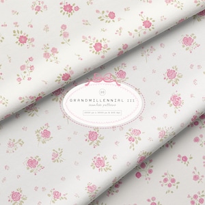 May include: White fabric featuring a floral pattern of pink roses and green leaves. The fabric is folded, displaying the design at various angles. The text "GRANDMILLENNIAL III seamless pattern" is present.
