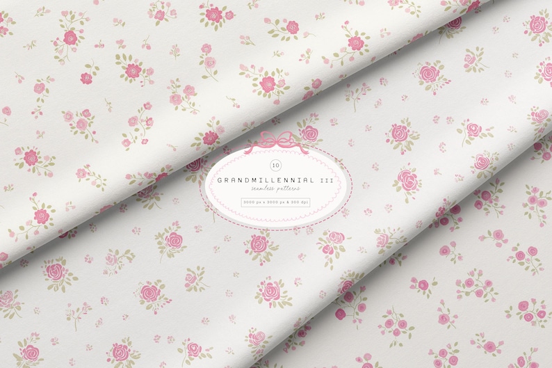 May include: White fabric featuring a floral pattern of pink roses and green leaves. The fabric is folded, displaying the design at various angles. The text "GRANDMILLENNIAL III seamless pattern" is present.