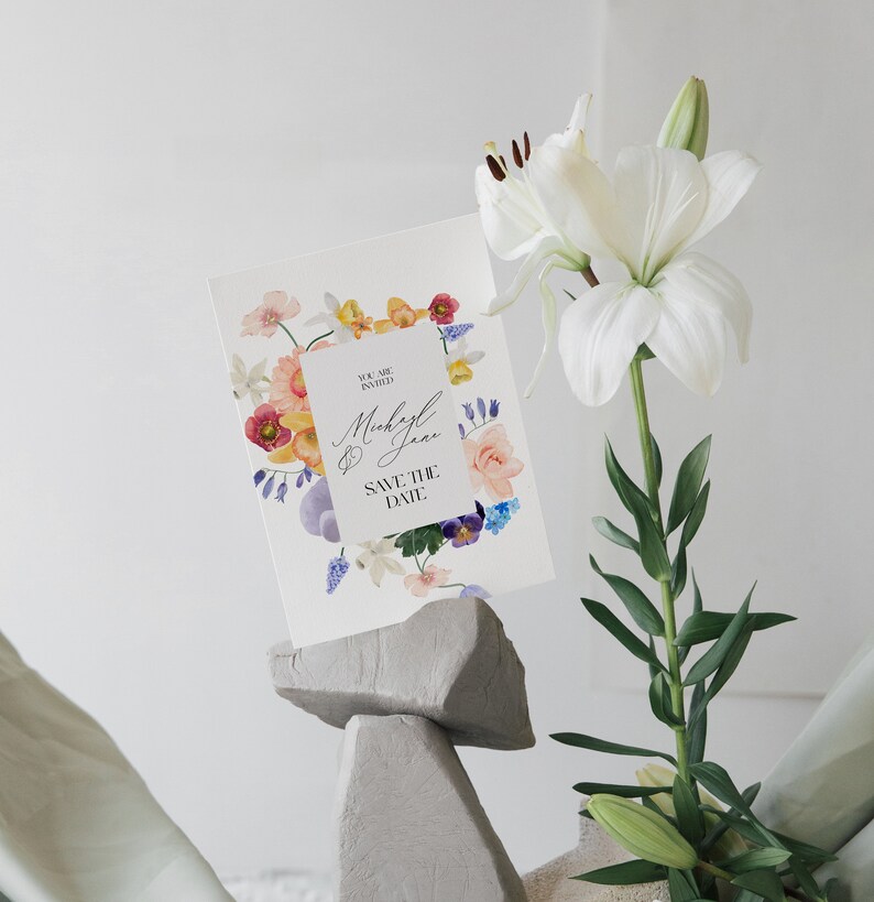 May include: A white card with a floral border and the text "You are invited" and "Michael & Jane Save the Date" in black lettering.