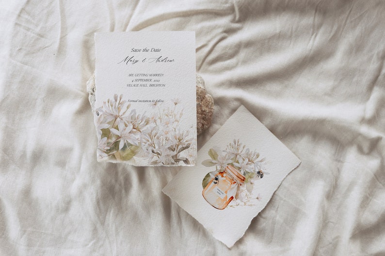 May include: Save the Date card with white flowers and green leaves. The text reads "Save the Date Mary & Andrew Are getting married 4 September 2022 Village Hall, Brighton Formal invitation to follow"
