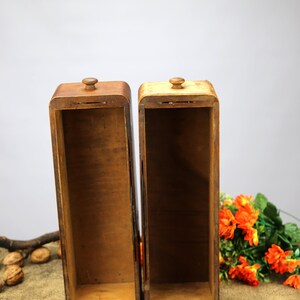 Peut inclure: Deux bo&icirc;tes en bois avec couvercles, toutes deux ouvertes et vides. Les bo&icirc;tes sont en bois brun clair et ont une finition naturelle. Les bo&icirc;tes sont pos&eacute;es sur une surface en toile de jute.