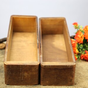 Peut inclure: Deux bo&icirc;tes rectangulaires en bois avec une finition en bois naturel. Les bo&icirc;tes sont vides et pos&eacute;es sur une surface en toile de jute.