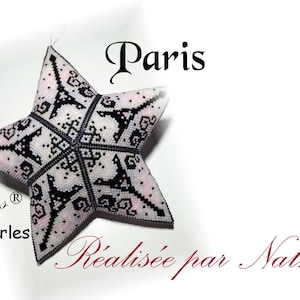 Peut inclure: Une décoration en forme d'étoile perlée avec un motif de la Tour Eiffel. L'étoile est blanche avec des détails noirs, et le mot "Paris" est écrit au-dessus. Le texte "Alexia Créations" et "Réalisée par Nathe" sont également visibles.