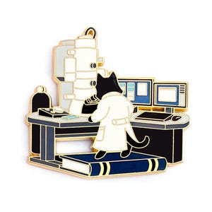 May include: A black cat wearing a white lab coat stands on a book in front of a gold-coloured electron microscope and computer monitors. The cat is looking at the microscope.