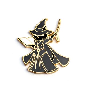 May include: A black cat wearing a gold wizard hat and robe, holding a book and a wand. The cat is casting a spell.
