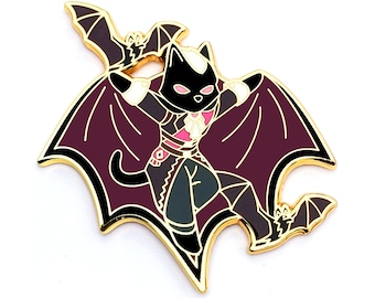 Puede incluir: Pin de esmalte dorado con un gato negro vestido de vampiro con una capa y alas moradas. El gato lleva un collar rosa y lleva un pequeño murciélago en la boca.