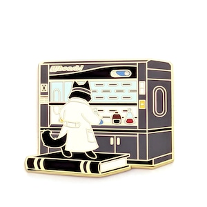 May include: A black and gold enamel pin featuring a cat wearing a white lab coat standing on a large book in front of a laboratory cabinet. The cabinet has the word "Whoosh!" printed in white at the top, with various glass beakers and flasks visible.