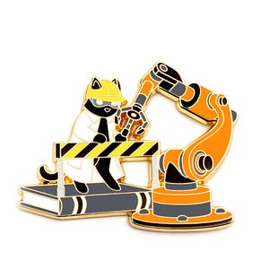 May include: A black cat wearing a yellow hard hat and a white lab coat stands on a platform with a yellow and black striped barrier. The cat is holding a robotic arm with a black and orange claw. The robotic arm is attached to a base with a black and orange design.