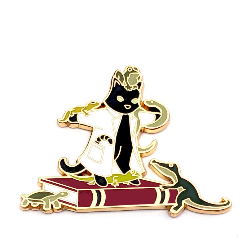 May include: A black cat wearing a white lab coat and holding a lizard in each hand stands on a red book. The cat has a green lizard on its head and a snake wrapped around its neck. A green alligator and a turtle are on the book.