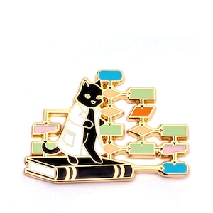 May include: A gold-toned enamel pin featuring a black cat wearing a white lab coat, standing on a black book. The cat is positioned in front of a complex flowchart with various colored rectangular and diamond-shaped boxes connected by thin lines.