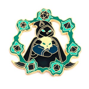 May include: Enamel pin featuring a robed figure holding a skull, surrounded by a teal and gold geometric design. The figure is wearing a black cloak with teal accents. The pin has a gold border and is set against a white background.