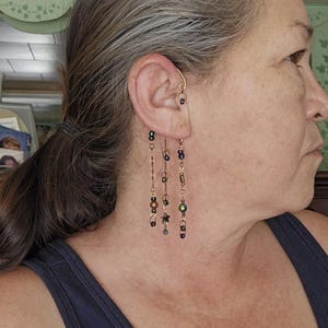 May include: A white ceramic mug with a black handle and the text "But First, Coffee" in a bold, black font. The mug is set against a blurred background, suggesting a cozy setting.