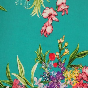 May include: A vibrant teal fabric featuring a floral pattern. The design includes pink, red, yellow, and purple flowers with green leaves. The flowers are scattered across the fabric, creating a lively and colorful design.