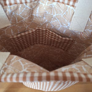 Peut inclure: Un sac cabas en vichy brun et blanc avec une doublure &agrave; imprim&eacute; floral brun et blanc. Le sac a une petite poche int&eacute;rieure en vichy brun et blanc.