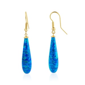 May include: A pair of gold teardrop earrings with blue opal stones.