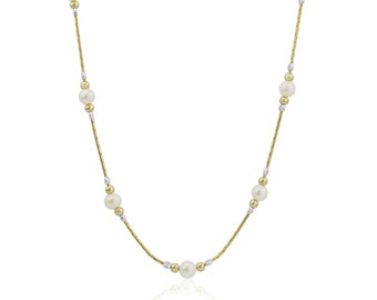 May include: A gold and silver chain necklace with white pearls. The chain is made of small, linked metal pieces.