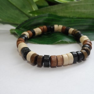 May include: A wooden bracelet with black, brown, and white beads.
