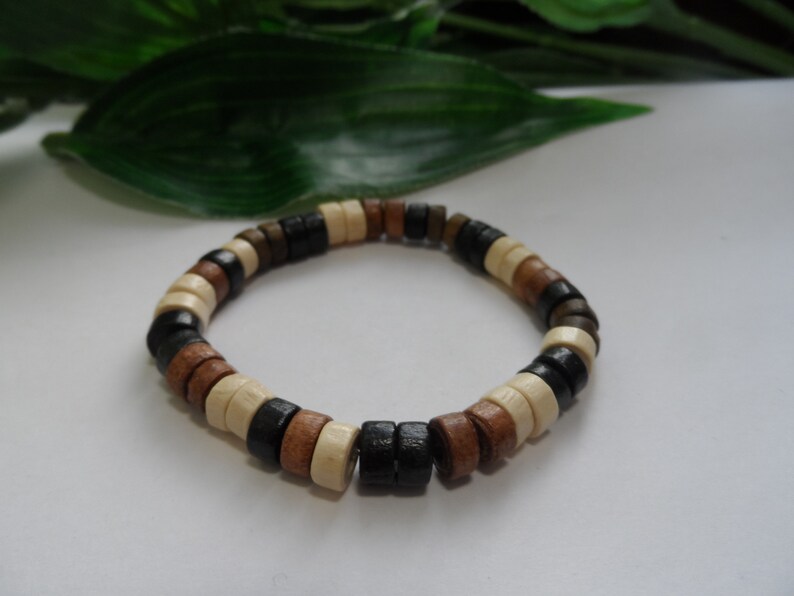 May include: A wooden bracelet with black, brown, and white beads.