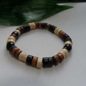 May include: A wooden bracelet with brown, black, and white beads.