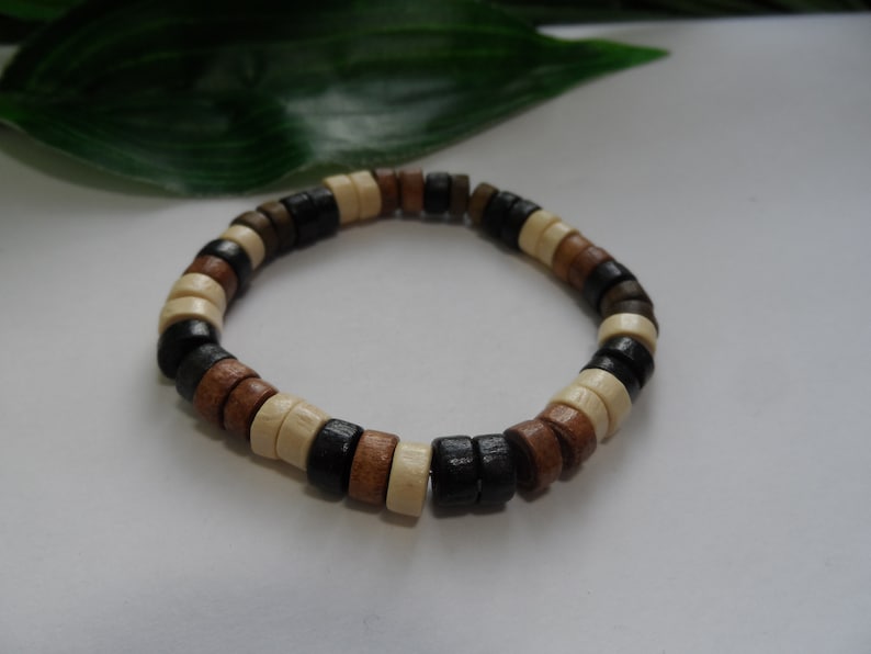 May include: A wooden bracelet with brown, black, and white beads.