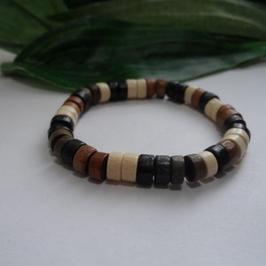 May include: A wooden beaded bracelet with brown, black, and white beads.