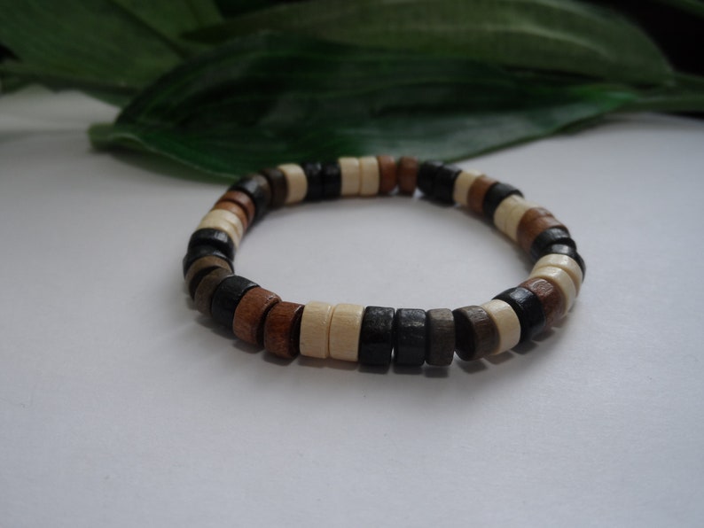 May include: A wooden beaded bracelet with brown, black, and white beads.