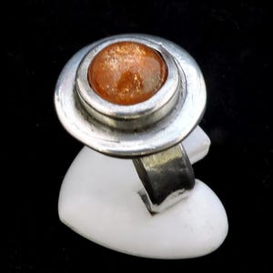 Anillo de mujer redondo y plateado con una piedra natural naranja, joyería única y original de piedra de sol, anillo hecho a mano.