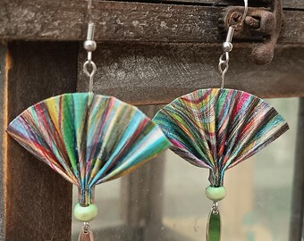 Könnte beinhalten: Ein Paar handgefertigte Ohrringe mit fächerförmigen Papierdesigns in lebendigen Farben wie Grün, Blau und Rot. Jeder Ohrring hat eine kleine grüne Perle und einen länglichen, silberfarbenen Anhänger. Die Ohrringe hängen an silberfarbenen Haken.