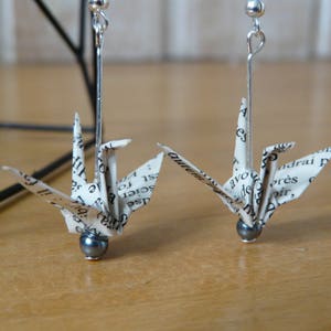 Orecchini origami a forma di gru su carta da libro