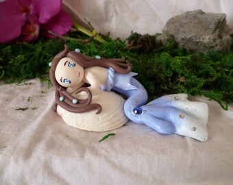 Fimo figurine of a mermaid on his shell