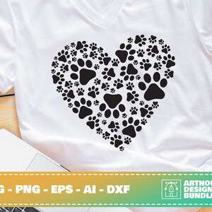 May include: A white t-shirt with a black paw print design in the shape of a heart. The design is made up of many paw prints of different sizes. The text "SVG - PNG - EPS - AI - DXF" is at the bottom of the image.