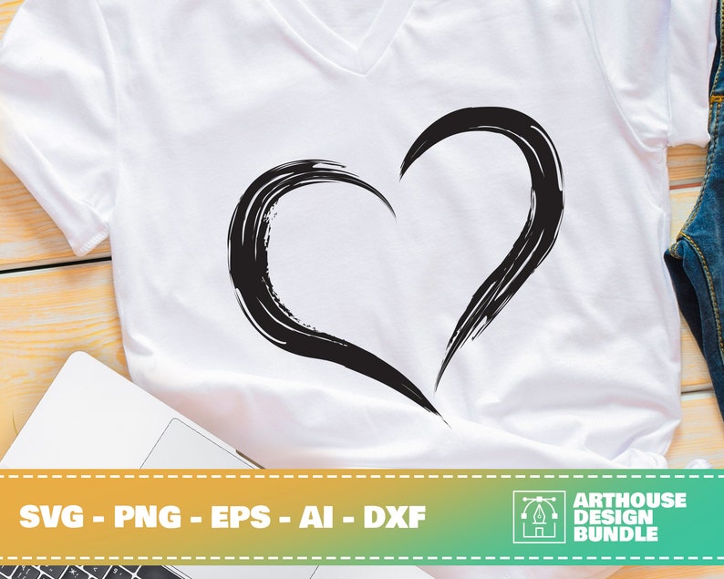 May include: White V-neck t-shirt featuring a large black heart design. The heart is created with brushstrokes, giving it a textured appearance. The bottom of the image includes the text "SVG - PNG - EPS - AI - DXF" and the "ARTHOUSE DESIGN BUNDLE" logo.