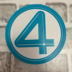 May include: A circular emblem featuring a prominent number four in a bold, stylized font. The design consists of a bright blue raised border and a matching blue number four set against a flat, white circular background, creating a clean contrast.