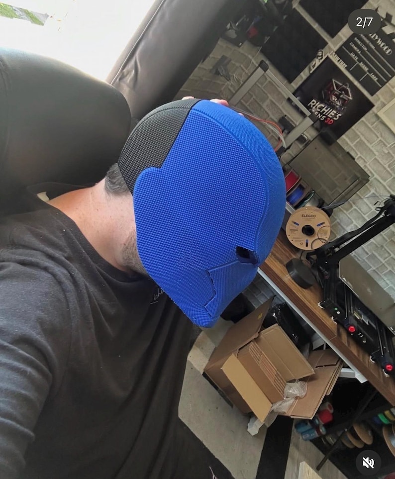 Op de afbeelding: Een blauw en zwart masker met een getextureerd oppervlak. Het masker is felblauw aan de voorkant en zwart aan de bovenkant. Het masker is waarschijnlijk een kostuum- of cosplay-item.