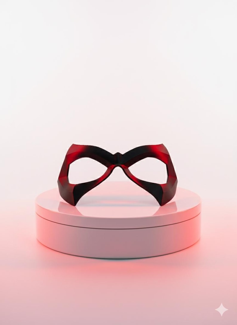 May include: A dark red, angular eye mask with a pointed bridge and wide, contoured openings for the eyes. The mask features a smooth, solid finish with sharp geometric edges and a symmetrical design that tapers toward the outer temples.