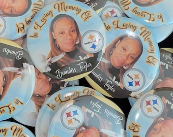May include: A collection of blue and yellow round buttons with a photo of a woman and the text "In Loving Memory Of Brandiss Taylor" and a Pittsburgh Steelers logo.