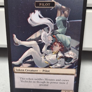May include: A fantasy-style illustration of a pilot token card for a trading card game. The card features a white and green illustration of two pilots in a space-like setting. The card text reads "PILOT" and "Token Creature - Pilot". The card text continues, "This token saddles Mounts and crews Vehicles as though its power were 2 greater". The card is numbered "1/1".
