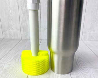 May include: A stainless steel tumbler with a bright yellow plastic base and a white plastic pipe.
