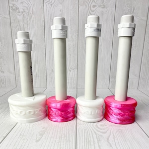 May include: Four white and pink water bottle stands with white PVC pipes and threaded connectors. The stands are labeled with the numbers 20oz, 20oz, 30oz, and 30oz. The stands are on a light wood-grain surface.