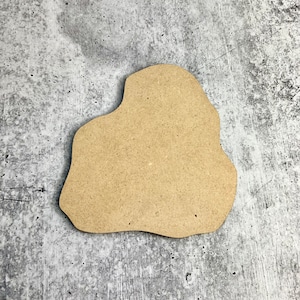 May include: A brown, irregularly shaped wooden cutout, resembling a cloud or a blob, against a gray textured background.