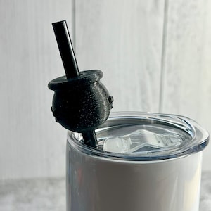 May include: A white stainless steel tumbler with a black lid and a black straw with a black silicone tip. The straw is inserted into the tumbler.