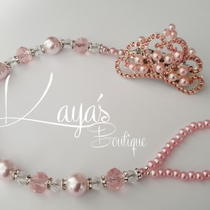 Op de afbeelding: Een roze en zilveren kralen tiara en armband set. De tiara heeft een decoratief ontwerp met roze imitatieparels en kristallen. De armband is gemaakt van roze imitatieparels en kristallen. De tekst "Laya's Boutique" staat in de afbeelding.