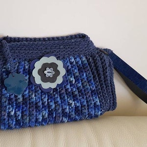 Pochette ad uncinetto in cotone azzurro, con fiore in pelle, manico da polso e zip