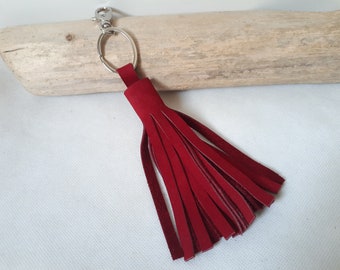 May include: A red leather tassel keychain with a silver metal ring and clasp.