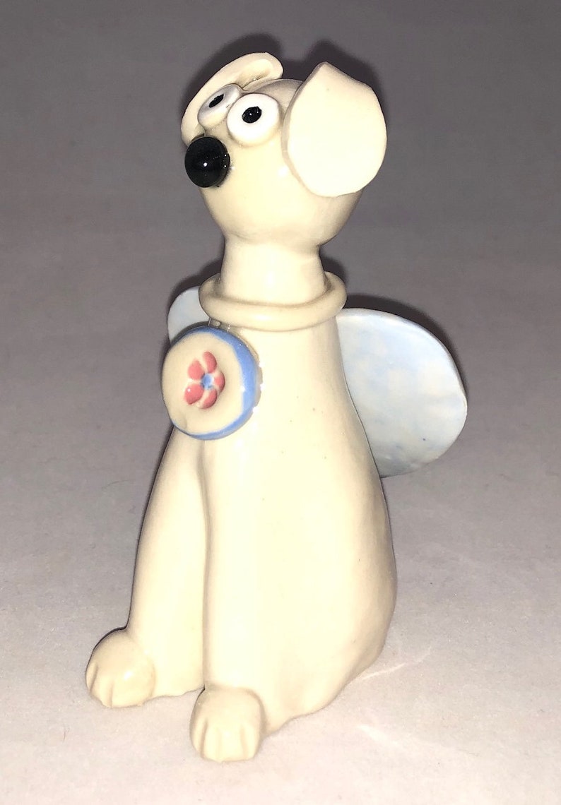 Dog angel with pink flower collar shaped Hand sculpted glazed. kiln fired to cone 6 and signed by the artist