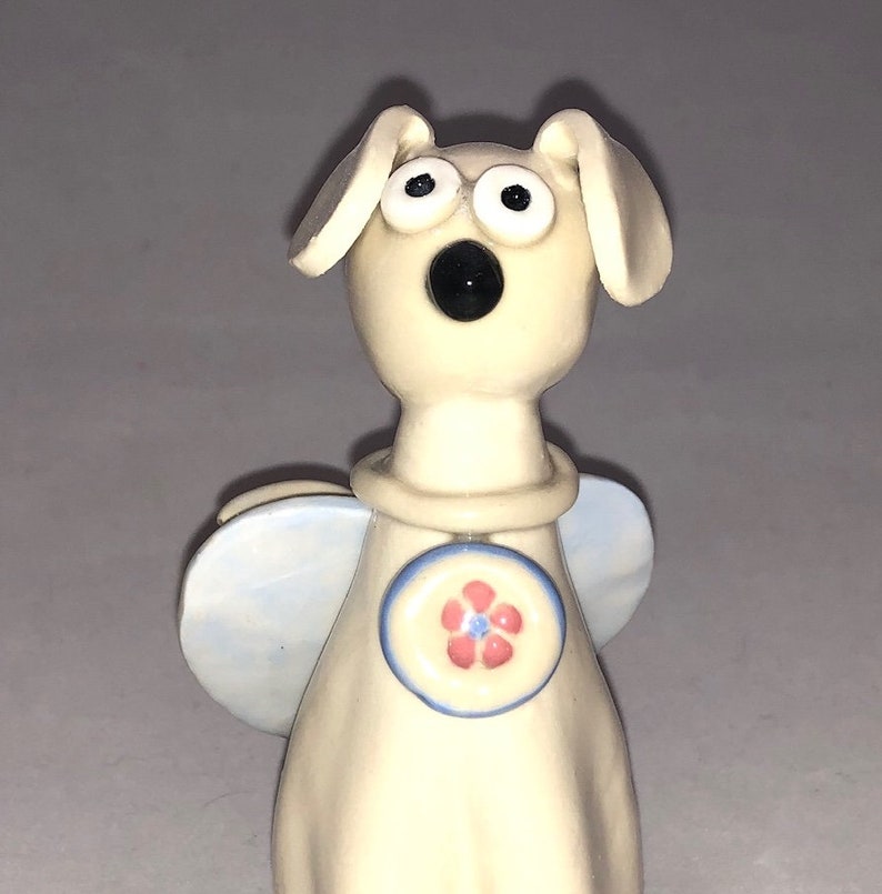 Dog angel with pink flower collar shaped Hand sculpted glazed. kiln fired to cone 6 and signed by the artist