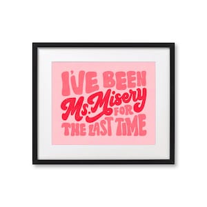 May include: A framed print with a pink background and red lettering that reads "I've been Ms. Misery for the last time."