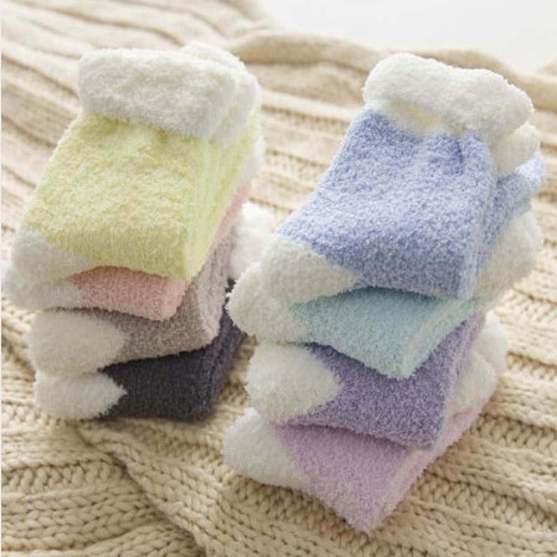 May include: A stack of fluffy, colorful socks with white cuffs. The socks are made of a soft, fuzzy material and are perfect for keeping your feet warm in the winter.