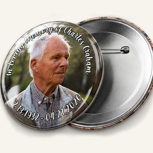 May include: A round button with a photo of an older man, the text "In Loving Memory of Charles Graham" and dates "02.13.1932 - 04.21.2026". The button is available in 1.25", 2.25", and 3" sizes. The button is made with high quality and vibrant print.