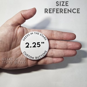 Peut inclure: Un bouton personnalis&eacute; blanc avec le texte "GEEKS IN THE STARS" et "CUSTOM BUTTONS" dans un design circulaire. Le bouton mesure 5,7 cm de diam&egrave;tre. Le texte "SIZE REFERENCE" est en haut. Le nom de la boutique Etsy est &eacute;galement visible.